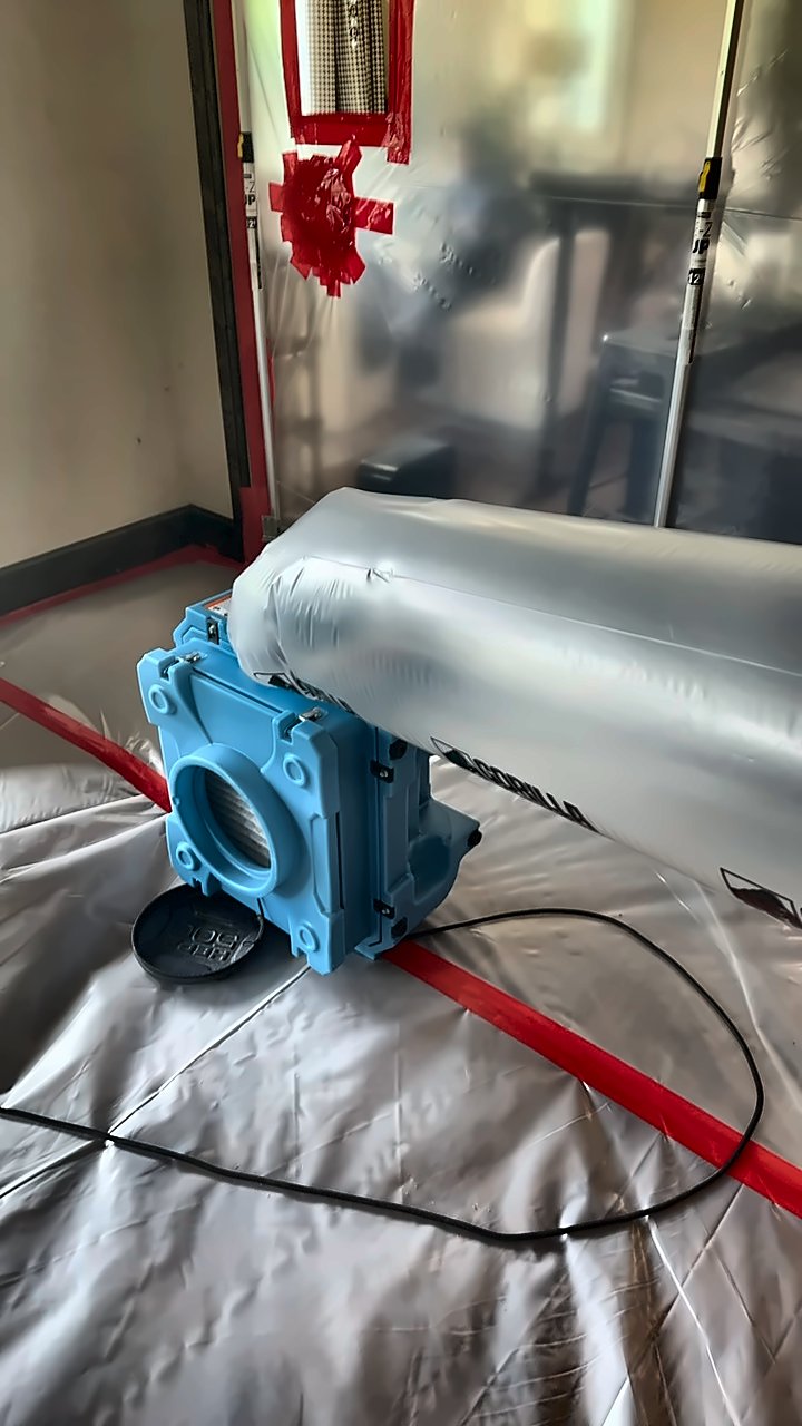An air scrubber runs inside a 4D Restoration containment zone, exhausting through inflated lay-flat ducting.