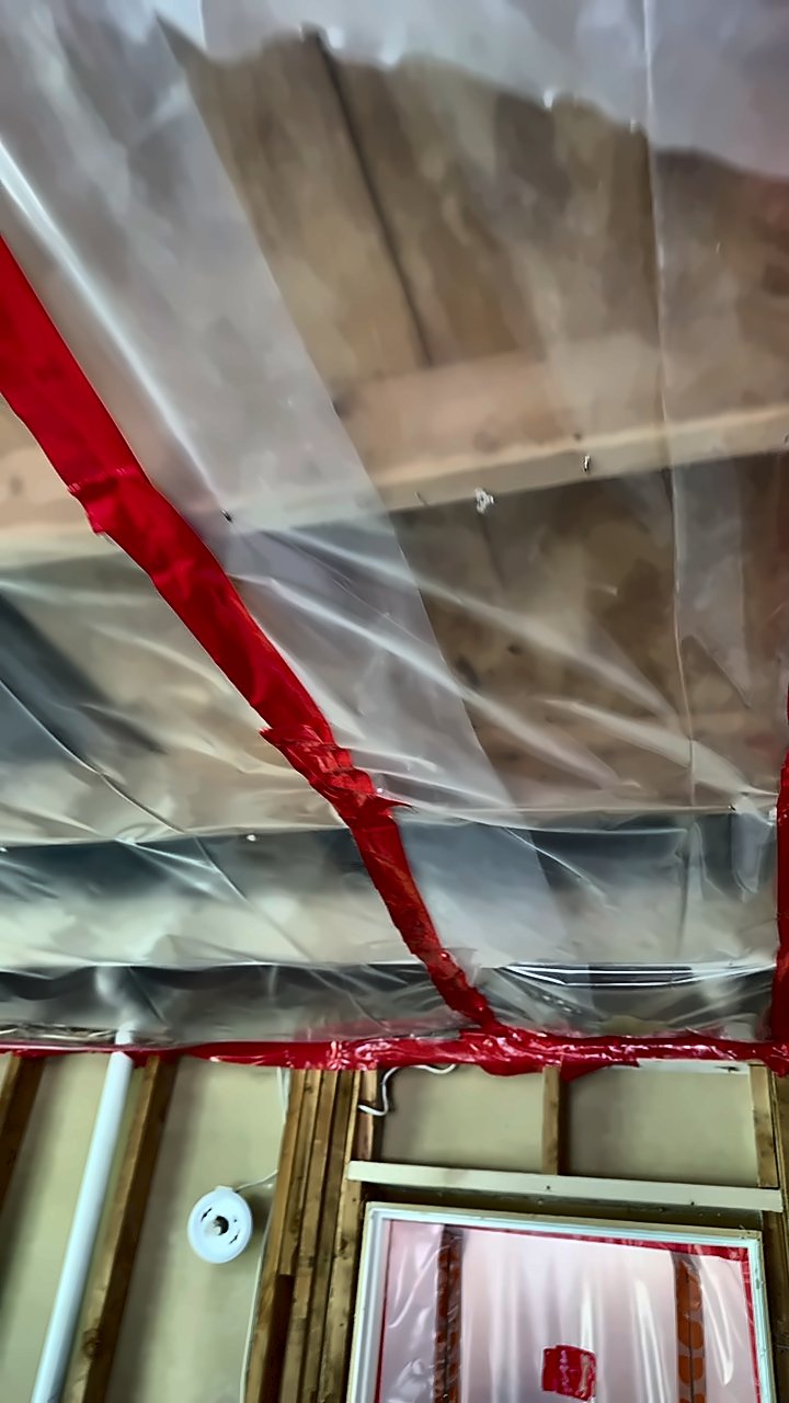 Clear sheeting taped to ceiling joists with red containment tape on a 4D Restoration mold job.