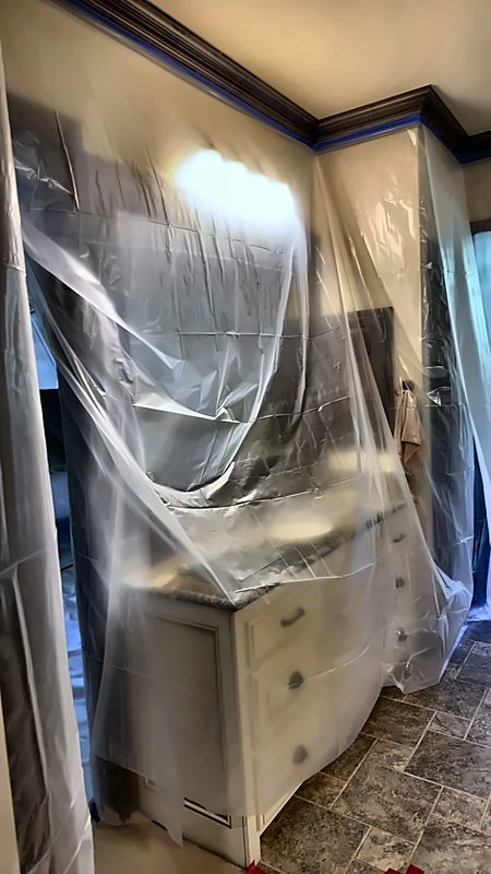 A bathroom vanity sealed under taped plastic sheeting by 4D Restoration before disturbance work.