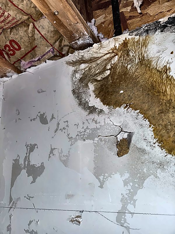A spreading brown stain, cracking paint, and exposed ceiling structure documented by 4D Restoration.